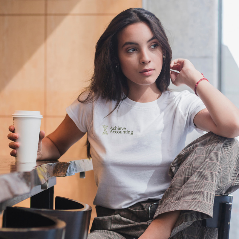 accounting branding logo design on white-shirt worn by a woman drinking coffee