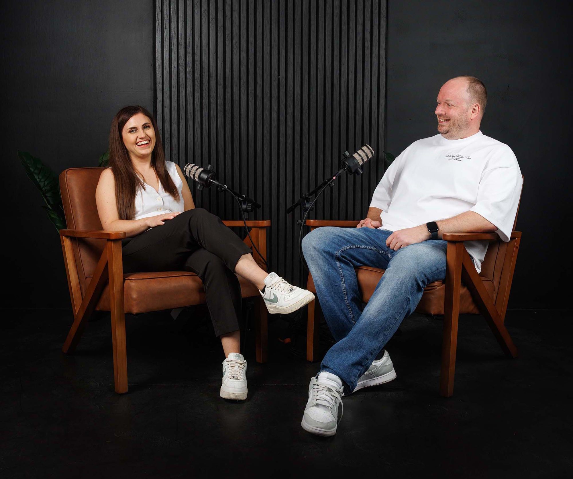 Nicole and Adam laughing together in chairs about branding services and on the call with a client